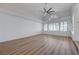 Bright living room features wood-look floors, a ceiling fan, and large windows with shutters at 519 Cayuga Ct, Boulder City, NV 89005