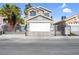 Two-story home with gray stucco, white garage door, black wrought iron gate, and palm trees at 5264 Silverheart Ave, Las Vegas, NV 89142