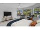 Bright main bedroom with large windows, two lounge chairs, and a ceiling fan at 5264 Silverheart Ave, Las Vegas, NV 89142