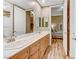 Bathroom featuring double sinks, wood-look flooring, and access to a bedroom at 5434 Pendini Point Ct, Las Vegas, NV 89141