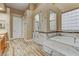 Spacious bathroom featuring wood-look flooring and a luxurious marble-clad soaking tub and shower at 5434 Pendini Point Ct, Las Vegas, NV 89141