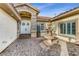 Elegant home entrance with stone facade, a water fountain, and a paved walkway at 5434 Pendini Point Ct, Las Vegas, NV 89141