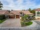 Attractive home exterior featuring a three-car garage, stone accents, and a beautifully paved driveway at 5434 Pendini Point Ct, Las Vegas, NV 89141