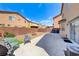 Wide backyard featuring a patio, gravel landscaping, fire pit, and distant desert homes at 5507 Nickel Ridge Way, Las Vegas, NV 89122