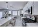 Modern kitchen with a spacious island, pendant lights, stainless steel appliances, and grey backsplash at 5507 Nickel Ridge Way, Las Vegas, NV 89122