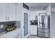 Kitchen with stainless steel appliances, white cabinets, marble counters, and a decorative pantry door at 5507 Nickel Ridge Way, Las Vegas, NV 89122