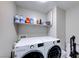 Organized laundry room with a modern, white washer and dryer set and shelving at 5507 Nickel Ridge Way, Las Vegas, NV 89122