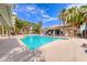 Community pool with ample lounge seating surrounded by lush landscaping and palm trees at 5507 Nickel Ridge Way, Las Vegas, NV 89122