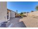 Low maintenance backyard featuring gravel, mature landscaping, perimeter fencing and home exterior at 5732 Colwood Ln, Las Vegas, NV 89130