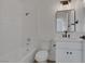 All-white bathroom with a shower over tub, a vanity, and modern lighting fixtures at 5732 Colwood Ln, Las Vegas, NV 89130