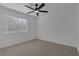 Bright bedroom featuring neutral carpet, a ceiling fan, and a window with blinds at 5732 Colwood Ln, Las Vegas, NV 89130