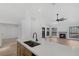 Bright, open kitchen with stainless steel sink, stone countertops, leading into the living room with fireplace at 5732 Colwood Ln, Las Vegas, NV 89130