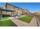 Backyard featuring artificial turf, brick trim, a concrete patio, block wall, and patio furniture at 5736 Clear Haven Ln, North Las Vegas, NV 89081