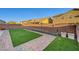 Backyard featuring artificial turf, brick trim, a rock wall, a concrete patio, and planters at 5736 Clear Haven Ln, North Las Vegas, NV 89081