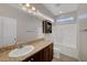 Bathroom with granite countertop, white sink, vanity cabinet, shower, toilet, and frosted window at 5736 Clear Haven Ln, North Las Vegas, NV 89081