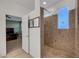 Bathroom featuring walk-in shower with decorative tile and an open door leading to bedroom at 5736 Clear Haven Ln, North Las Vegas, NV 89081