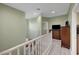 Hallway with light green walls, wood flooring, white banister, and wooden dresser at 5736 Clear Haven Ln, North Las Vegas, NV 89081