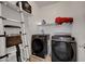 Laundry room with dark washer and dryer, ladder, shelves and white walls at 5736 Clear Haven Ln, North Las Vegas, NV 89081