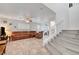 Bright living room with tile floors, brown couches and a staircase with white banister in view at 5736 Clear Haven Ln, North Las Vegas, NV 89081