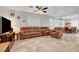 Open-concept living area featuring tile flooring, a ceiling fan, and comfortable brown leather seating at 5736 Clear Haven Ln, North Las Vegas, NV 89081