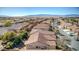 Wide aerial view of homes with tile roofs in a desert community showcasing mountain backdrop and neighborhood streets at 5891 Alfano Ave, Pahrump, NV 89061