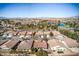 Scenic aerial view of desert homes in a golf course community with tile roofs, mature trees, and a lake at 5891 Alfano Ave, Pahrump, NV 89061