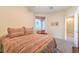 Comfortable bedroom featuring a striped bedspread, neutral walls, a window, and an open doorway to the en suite at 5891 Alfano Ave, Pahrump, NV 89061