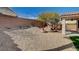 Gravel backyard with a covered patio, desert landscaping, and a block wall at 5965 Poplar Tree St, Las Vegas, NV 89148