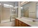 Bright bathroom with a double sink vanity and a glass-enclosed shower/tub combo at 5965 Poplar Tree St, Las Vegas, NV 89148