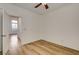 Bedroom with light wood floors, ceiling fan, and window with backyard view at 5965 Poplar Tree St, Las Vegas, NV 89148