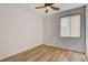 This minimal bedroom includes wood flooring, a ceiling fan, and window blinds at 5965 Poplar Tree St, Las Vegas, NV 89148