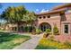 Beautiful clubhouse exterior featuring stone accents, lush landscaping and well-manicured lawn at 5965 Poplar Tree St, Las Vegas, NV 89148