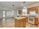 Cozy kitchen featuring an island, white appliances, and wood cabinetry at 5965 Poplar Tree St, Las Vegas, NV 89148