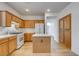 Cozy kitchen featuring an island, white appliances, and wood cabinetry at 5965 Poplar Tree St, Las Vegas, NV 89148