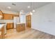 Bright kitchen features wood cabinets, island, wood-look flooring, and modern pendant lighting above the island at 5965 Poplar Tree St, Las Vegas, NV 89148