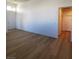 Bright living room with wood flooring, white walls, and a hallway to the bedrooms at 5965 Poplar Tree St, Las Vegas, NV 89148