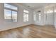 Bright living room featuring wood-look flooring and multiple windows for natural light at 5965 Poplar Tree St, Las Vegas, NV 89148