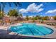 Sparkling blue community pool area featuring several lounge chairs and landscaped surroundings at 5965 Poplar Tree St, Las Vegas, NV 89148