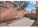 View of backyard showing brick fence, paver patio, and rocks at 6116 Casa Antiqua St, North Las Vegas, NV 89081