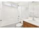 Bathroom featuring a shower-tub combo with white tile surround, wood vanity and bright light at 6116 Casa Antiqua St, North Las Vegas, NV 89081