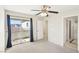 A standard-sized bedroom, with a window, ceiling fan, and sliding door leading to an exterior balcony at 6116 Casa Antiqua St, North Las Vegas, NV 89081