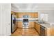 Well-lit kitchen with stainless steel appliances, wood cabinets, and hardwood floors at 6116 Casa Antiqua St, North Las Vegas, NV 89081