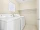 Bright laundry room with tile floors, shelving, and appliances at 6116 Casa Antiqua St, North Las Vegas, NV 89081