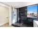 Bathroom featuring a glass-enclosed shower with black and white marble, plus a window with neighborhood views at 6628 Silver Penny Ave, Las Vegas, NV 89108