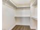 Walk-in closet featuring white shelving and neutral carpeting, offering ample storage space at 6628 Silver Penny Ave, Las Vegas, NV 89108