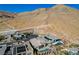 Aerial view of a luxury home with a sparkling pool, solar panels, and a stunning mountain backdrop at 6832 Apogee Ridge Ct, Las Vegas, NV 89135