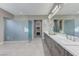 Modern bathroom featuring double sinks, a long vanity, large shower, and walk-in closet at 6832 Apogee Ridge Ct, Las Vegas, NV 89135