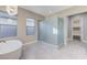 Bright bathroom with large enclosed shower, soaking tub under the window, and walk-in closet at 6832 Apogee Ridge Ct, Las Vegas, NV 89135