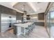 Open kitchen with stainless steel appliances, marble countertops, and a large island with bar stool seating at 6832 Apogee Ridge Ct, Las Vegas, NV 89135