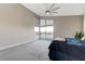 Bright main bedroom with neutral decor, large windows overlooking a pool, and a ceiling fan at 6832 Apogee Ridge Ct, Las Vegas, NV 89135